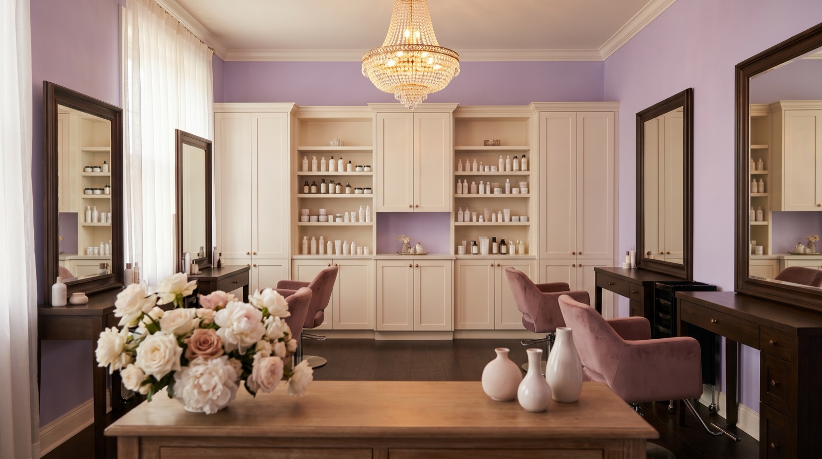 The warm, lavender-toned interior of MSL Salon Boutique — chandelier, white cabinetry, and floral touches